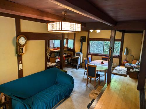 a living room with a blue couch and a table at 古民家のこのこ in Tanabe