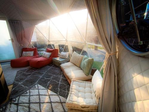 a room with couches and chairs in a tent at Casa Vacanze Borc dai Cucs in Faedis