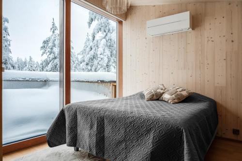 a bedroom with a bed and a large window at Borderlake One in Ruka