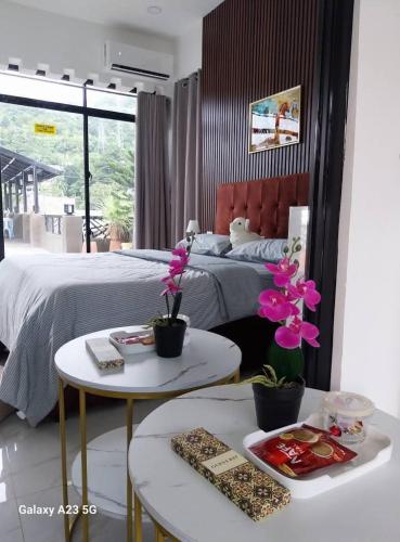 a bedroom with a bed and two tables with flowers at Buddy's Skybar & Suite in Guinsorongan