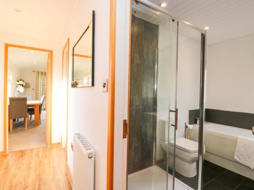 a glass shower in a bathroom with a table at Bluebell Lodge in Carnforth