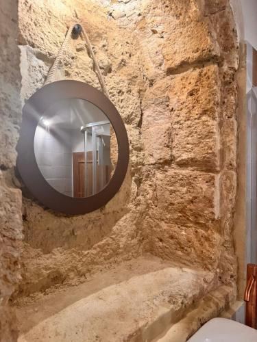a bathroom with a mirror on a stone wall at Nonna Pia in Noto