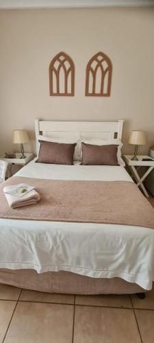 a bedroom with a large white bed with two tables at Bloemhoek Guest House in Centurion
