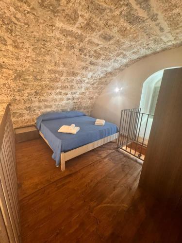 a bedroom with a bed in a brick wall at Nonna Pia in Noto