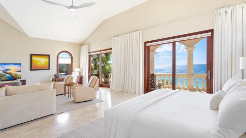 a white bedroom with a large bed and a living room at Sandcastle Villa in Crocus Hill