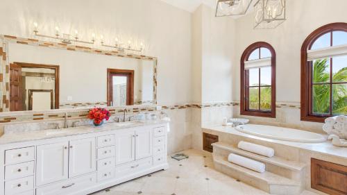 a bathroom with a tub and a sink and a mirror at Sandcastle Villa in Crocus Hill