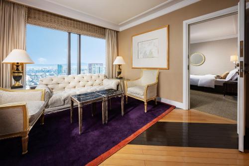 a living room with a couch and a large window at Hotel Hankyu International in Osaka