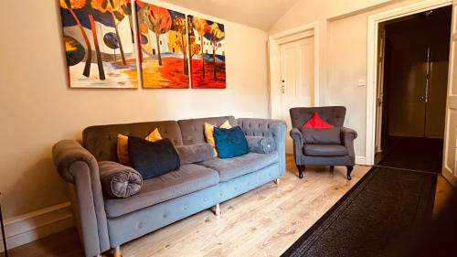 a living room with a blue couch and a chair at Stunning Stylish & Spacious Ground Floor Apartment, Kidderminster in Kidderminster