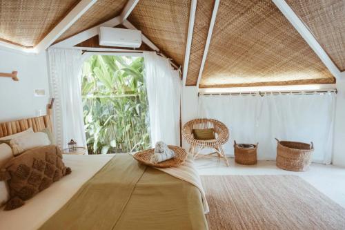 a bedroom with a bed and a large window at Punta Punta Surf Retreat in General Luna