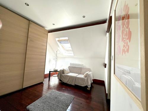 a living room with a chair and a window at Jolie chambre sous les toits in Dreux