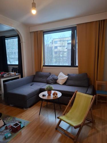 a living room with a couch and a table at Room near Tripla Pasila in Helsinki