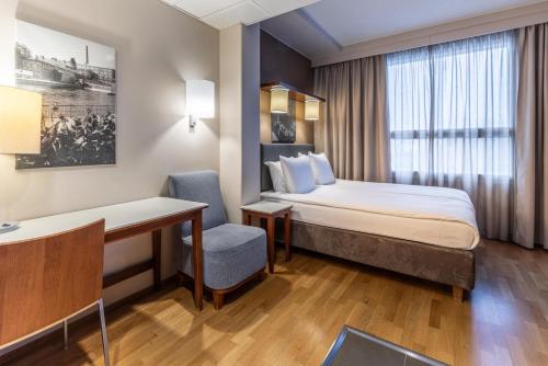 a hotel room with a bed and a desk at Scandic Postitalo in Tampere