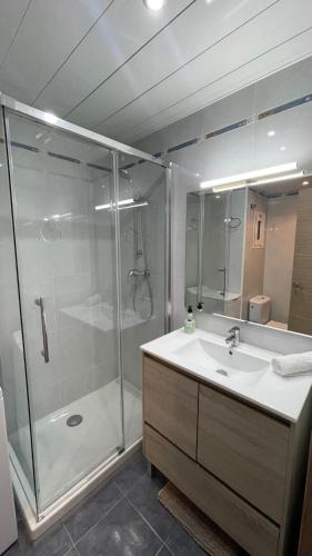 a bathroom with a glass shower and a sink at Pineda Beach PORT AVENTURA in La Pineda