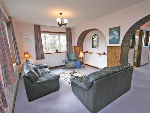 a living room with two leather couches and a television at Ken Maree in South Erradale