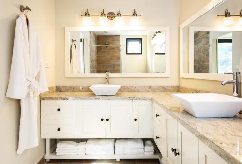 a bathroom with two sinks and two mirrors at Sandcastle Beach House in The Valley