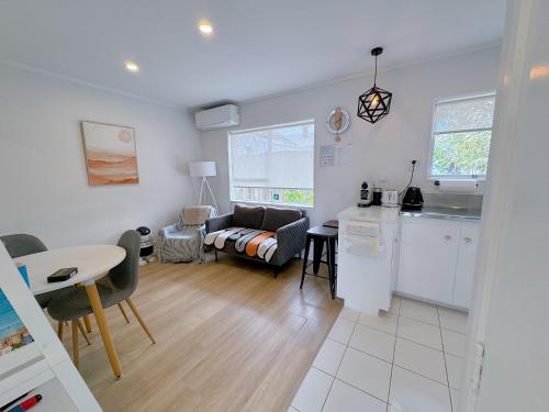 a kitchen and a living room with a couch and a table at Bright Eden Park two bed townhouse private parking in Auckland