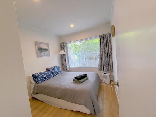 a small bedroom with a bed and a window at Bright Eden Park two bed townhouse private parking in Auckland