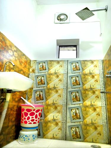 a bathroom with a wall of pictures on the wall at Hotel Rainbow in Yamunānagar