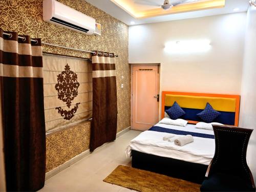 a bedroom with a bed and a curtain in it at Hotel Rainbow in Yamunānagar