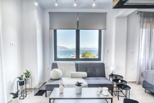 a living room with a couch and a large window at Maison Poème Luxury Apartments in Aiándion