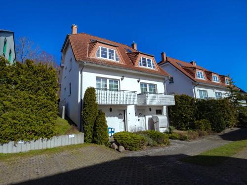 a white house with a red roof at Fährhaus Sellin - Ferienwohnung 2 in Ostseebad Sellin