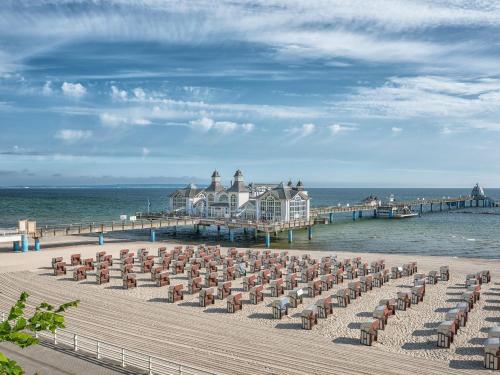 a group of chairs on a beach with a pier at Fährhaus Sellin - Ferienwohnung 2 in Ostseebad Sellin
