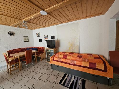 a bedroom with a bed and a table and a dining room at 2 Ferienwohnungen Klenk in Gruibingen