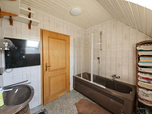 a bathroom with a bath tub and a sink at 2 Ferienwohnungen Klenk in Gruibingen