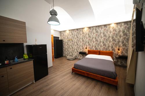 a bedroom with a bed and a kitchen in it at Chivasso centro - Garden Apartments in Chivasso