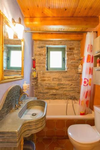 a bathroom with a sink and a tub and a toilet at villapetramarina in Tsakaíoi