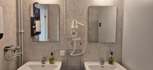 a bathroom with two sinks and a mirror at Kalkbrottets Vandrarhem in Slite