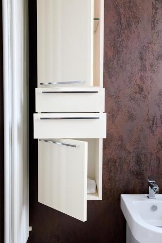 a bathroom with white drawers and a sink at Art-inn in San Vendemiano