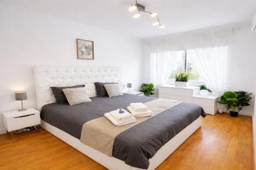 a bedroom with a large bed with two towels on it at Lo Exclusive Lisboa - Apartament with terrace and golf view in Charneca