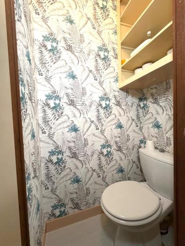 a bathroom with a toilet and a floral wallpaper at Chill & Nature in Nargis
