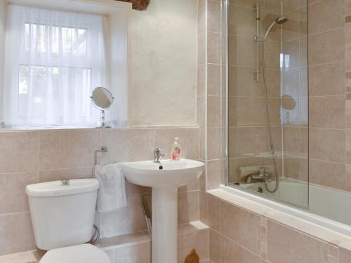a bathroom with a toilet and a sink and a shower at Mont Stewart Cottage in Whiting Bay