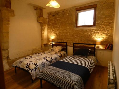 two beds sitting next to each other in a room at Gîte Val de Loire Le Puits in Loudun