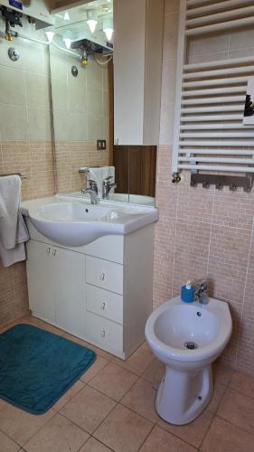 a bathroom with a sink and a toilet and a mirror at Casa Rosa in Rocca San Giovanni