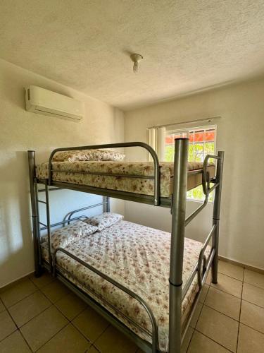 two bunk beds in a room with a window at Casa completa en Acapulco in Acapulco