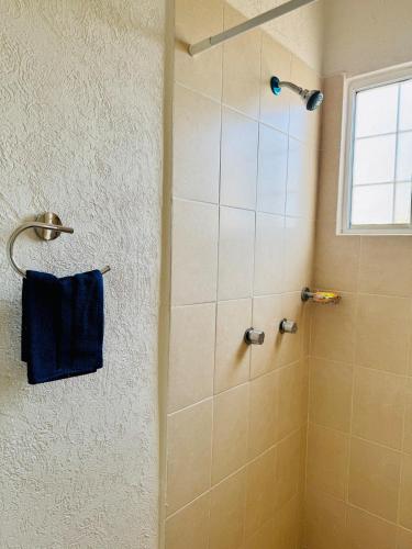 a bathroom with a shower with a blue towel at Casa completa en Acapulco in Acapulco