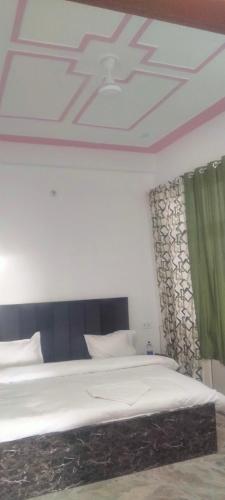 a bedroom with a large bed with a ceiling at Hotel Kanha palace in Lucknow