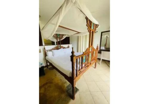 a bedroom with a bed with a canopy at Mango Villa Mtwapa in Mtwapa