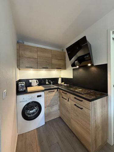 a kitchen with a washing machine and a washer at Appartement tout confort très proche mer in Villers-sur-Mer