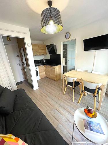 a living room with a couch and a table at Appartement tout confort très proche mer in Villers-sur-Mer