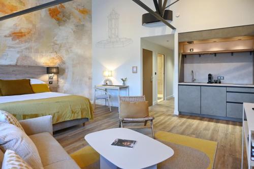 a hotel room with a bed and a kitchen at Walnut Bistro & Suites in Eymet