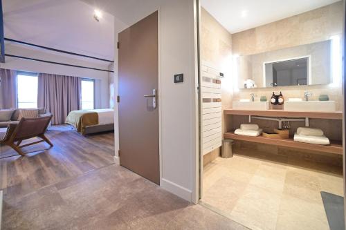 a room with a bathroom with a sink and a mirror at Walnut Bistro & Suites in Eymet
