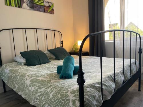 a bedroom with a bed with a blue pillow on it at Vert Bocage à Bâlines in Balines