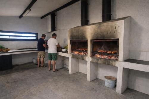 two men standing in a kitchen preparing food at Apto Espert l PISCINA l Cine l Garaje l BBQ l Wifi in Biescas