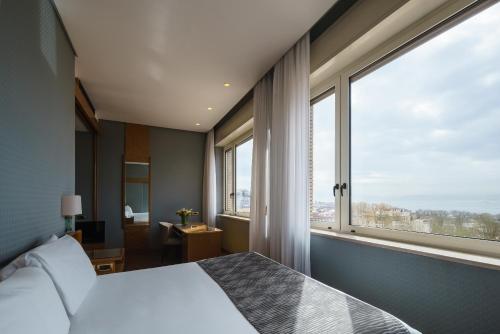a bedroom with a bed and a large window at Exe Majestic in Naples