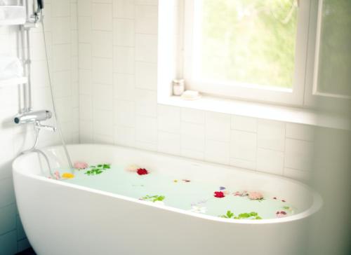 una vasca da bagno con fiori dipinti sopra in un bagno di Wiks Slott a Vik