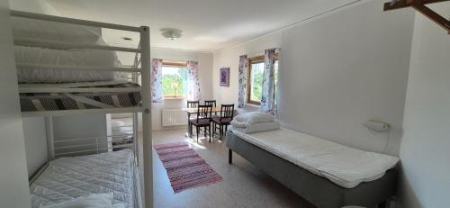 a dorm room with a bunk bed and a table at Kalkbrottets Vandrarhem in Slite